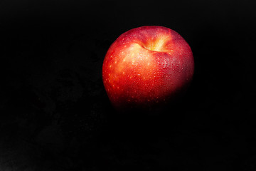 Fototapeta na wymiar Manzana deliciosa desvaneciéndose entre el fondo oscuro.