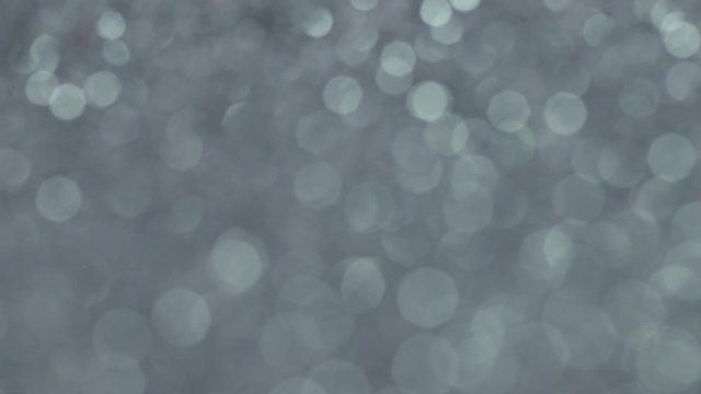 360 rotation background. Holiday shiny backdrop. Gray shiny surface with metallic sheen. Abstract beautiful gray background. Sparkles on the background. Bokeh background.