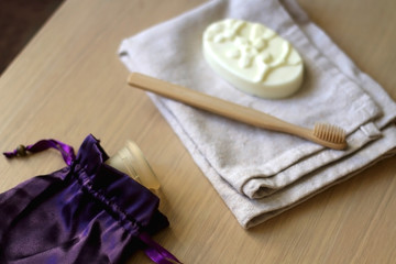 Fototapeta na wymiar Linen cloth, soap, bamboo toothbrush and menstrual cup. Zero waste bathroom products. Selective focus.