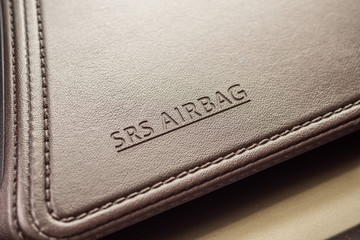 airbag safety sign on brown leather texture in modern car