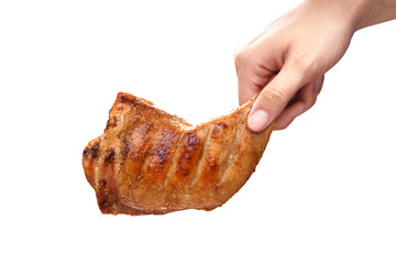 Hand holding grilled chicken thigh on white background