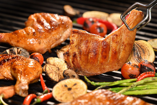 Grilled chicken thigh with various vegetables on the grill