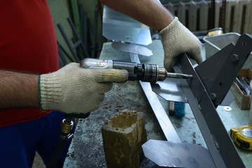 Fitter hands working with a pistol type pneumatic drill