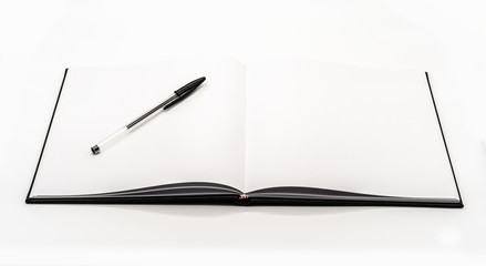 Naklejka premium Cuaderno en blanco abierto con un bolígrafo negro