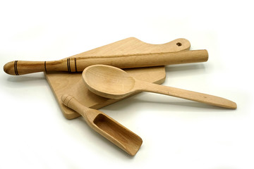 Wooden kitchen utensils on white background. Cutting board, spoon and scoop.