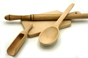 Wooden kitchen utensils on white background. Cutting board, spoon and scoop.