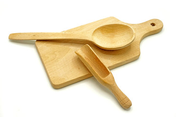 Wooden kitchen utensils on white background. Cutting board, spoon and scoop.