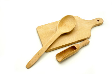 Wooden kitchen utensils on white background. Cutting board, spoon and scoop.