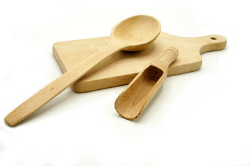 Wooden kitchen utensils on white background. Cutting board, spoon and scoop.