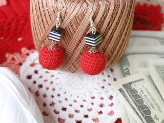 Red crocheted earrings, jewelry, women's jewelry handmade and needlework. The concept of needlework business and sales. Online store