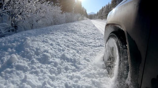 SUV car driving in deep snow on a Winter country road