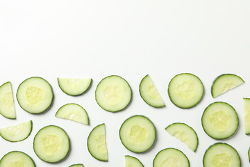 Flat lay with cucumber slices on white background, top view