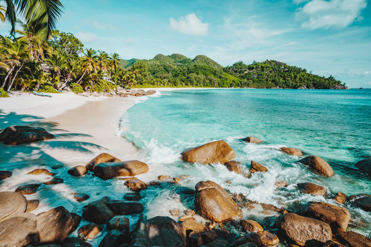 Mahe, Seychelles. Beautiful Anse intendance, tropical beach with ocean wave rolling towards sandy beach. Coconut palm trees on shore in background © Igor Tichonow