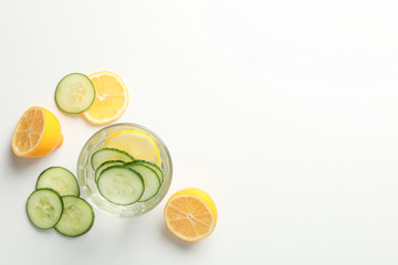 Glass with infused water, cucumber and lemon slices on white background, copy space