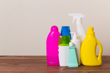 Cleaning product plastic container for house clean on wooden table and gray background . household chemicals