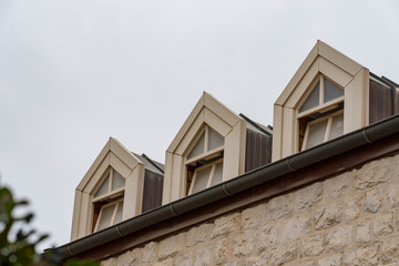 Roof with three beautiful white dormer windows. Ancient round dormer windows in rooftop....