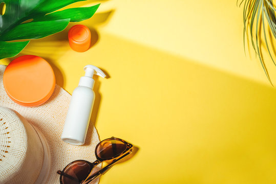 Sunscreen. Woman's hat with sunglasses and protection cream spf Beach accessories. Summer Travel Vacation Concept