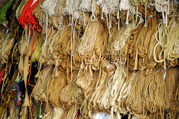 Twines and ropes of different sizes and colors hanging in shop.