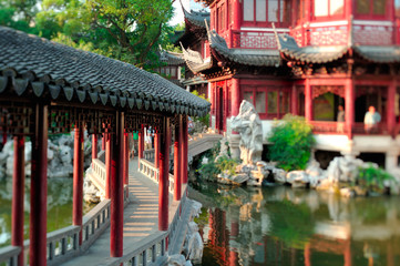 Traditional Asian garden with pond in sunset warm light. Special lens used to obtain miniature selective focus effect.