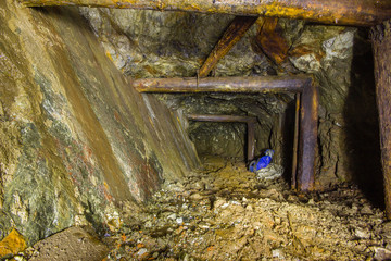 Old copper mine underground tunnel with incline wall and wooden stands