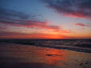 Fototapeta na wymiar The waves wash the sandy beach at sunrise