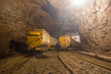 Gold mine underground tunnel with mining ore carts wagons