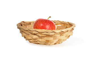 Fototapeta na wymiar small wicker willow basket with red apple isolated on a white background. Healthy eating concept