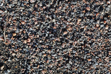 Small colorful rocks mostly brown and grey colors. Spa like calm, relaxing background texture. Photographed in Finland during a sunny spring day. Beautiful natural rock pattern. Closeup color photo.