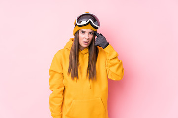 Young caucasian skier woman isolated showing a disappointment gesture with forefinger.