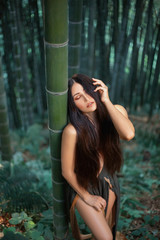 Pretty sexy Amazonian relax silence in bamboo forest. hand touch long hair, eyes closed. nymph...