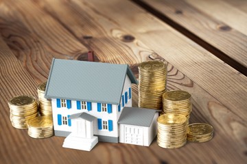 Model of house with coins on a table