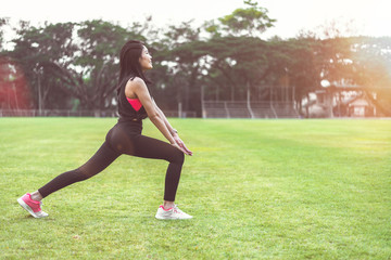 Women perform exercises by focusing on their legs before exercising in the park.