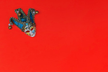 Venetian carnival mask on a red background. Flat lay, copy space, top view.