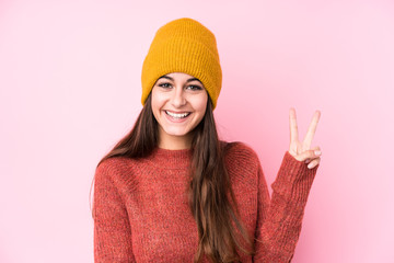 Young caucasian woman wearing a wool cap showing number two with fingers.