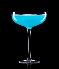 Glass for blue champagne with splashes isolated on black background.