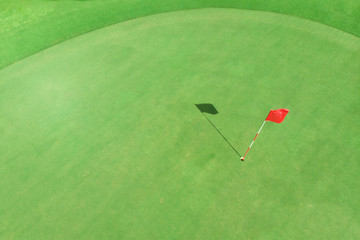 top view of golf pole on the green in a golf course with blank copyspace