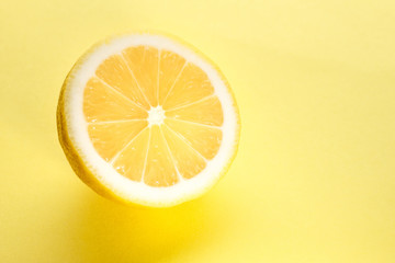 Sliced bright juicy lemon on a yellow background.