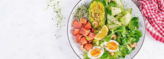 Ketogenic diet breakfast. Salt salmon salad with greens, cucumbers, eggs and avocado. Keto/paleo lunch. Top view, banner - obrazy, fototapety, plakaty