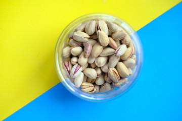 top view of pistachios in a jar on color background 