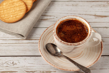 Cup of aromatic coffee on an old white wooden table.