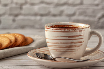 Cup of aromatic coffee on an old white wooden table.