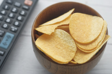 Close up of chips in a bowl with tv remote 