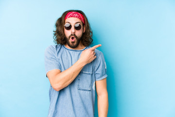 Young long hair man wearing a festival hipster look isolated pointing to the side