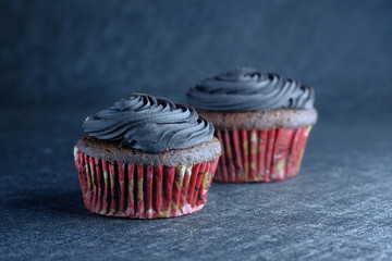 Close up of fresh and homemade cupcake on table, on black background 