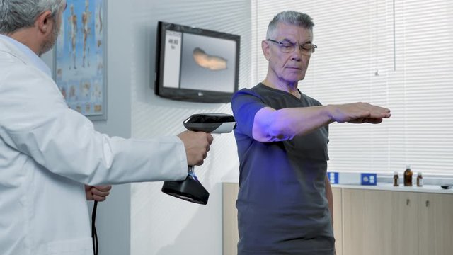 doctor scanning elbow patient with a hand scanner 3d to capture data to create a miodel and make an orthotic brace or prosthesis