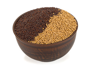 Mustard seeds black and white in a plate isolated on a white background