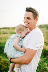 The Daughter hugging father on nature on summer day on holiday. Dad hold girl in the park. Concept of happy family. Closeup.