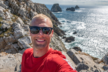 Portrait beau gosse charmant jeune homme caucasian blond aux yeux bleu joyeux et confiance en soi séduisant chanceux charismatique européen heureux zen pointe de pen hir bretagne finistère france nord