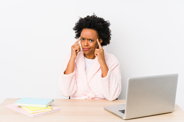 Middle aged african american woman working at home isolated focused on a task, keeping forefingers pointing head.