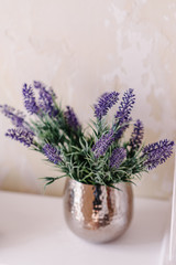 Bunch of lavender and greenery in a vase on a white table on a vintage shelf over pastel wall. Chic provance interior decor for farm home style. Provence home decoration.